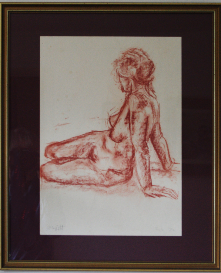 A framed nude study in red chalk.